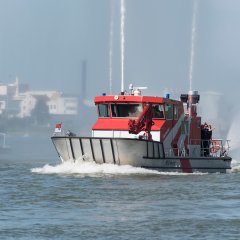 Das Hilfeleistungsboot HLB Hecht auf dem Rhein mit Wasserspritze in Aktion.